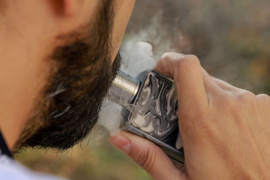 Un hombre vapeando. Un hombre vapeando.