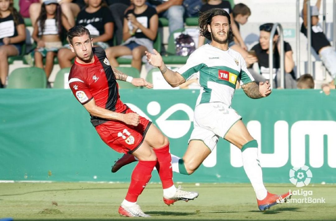 El jugador del Elche Juan Cruz y el rayista Embarba en un momento del partido El jugador del Elche Juan Cruz y el rayista Embarba en un momento del partido