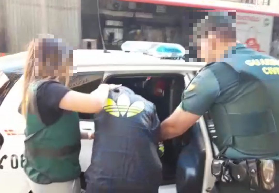 Agentes de la Guardia Civil introducen a uno de los detenidos en un coche patrulla Agentes de la Guardia Civil introducen a uno de los detenidos en un coche patrulla