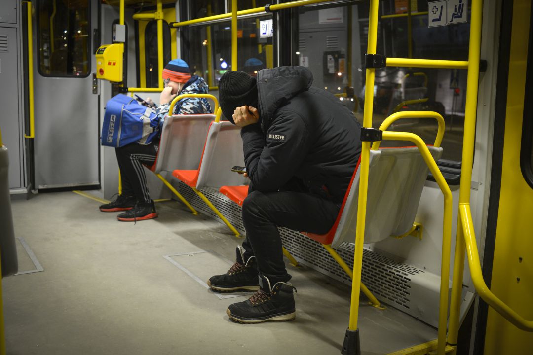 Imagen de un joven mirando el móvil mientras viaja en un autobús Imagen de un joven mirando el móvil mientras viaja en un autobús