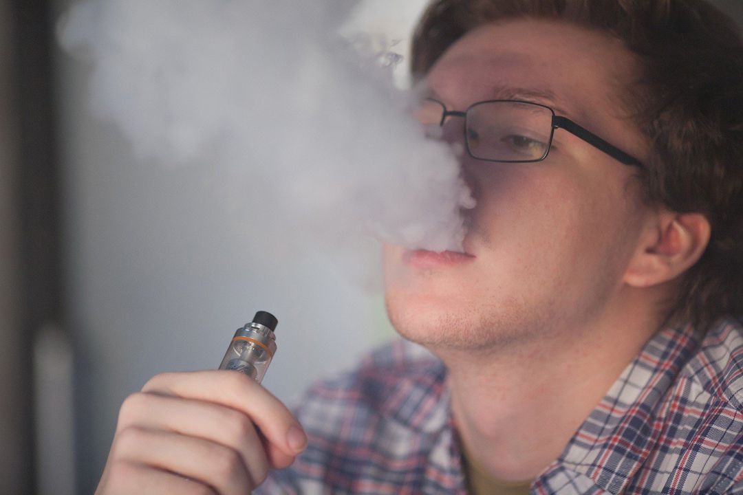 Un adolescente vapeando. Un adolescente vapeando.