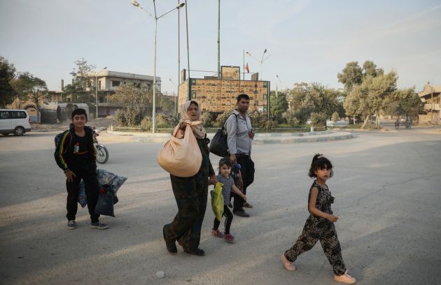 Una familia siria cargando sus pertenencias, mientras huyen de Sari Kani, en el noreste de Siria. Una familia siria cargando sus pertenencias, mientras huyen de Sari Kani, en el noreste de Siria.