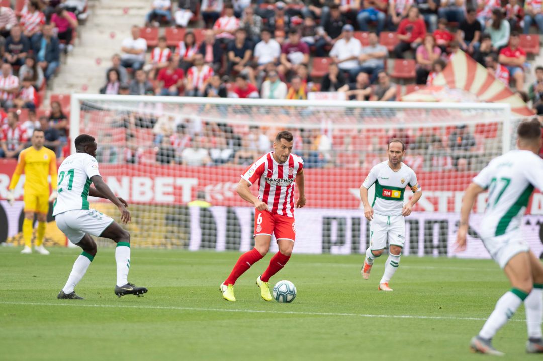 El capitán del Girona Granell, con el balón, rodeado de jugadores del Elche El capitán del Girona Granell, con el balón, rodeado de jugadores del Elche
