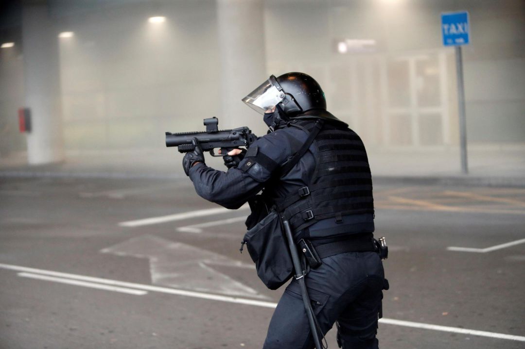 Miembros de los Mossos cargan contra los centenares de personas que se agolpaban ante el Aeropuerto del Prat. Miembros de los Mossos cargan contra los centenares de personas que se agolpaban ante el Aeropuerto del Prat.