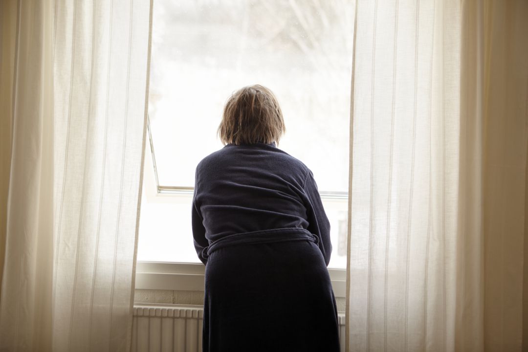 Una mujer mira por la ventana Una mujer mira por la ventana