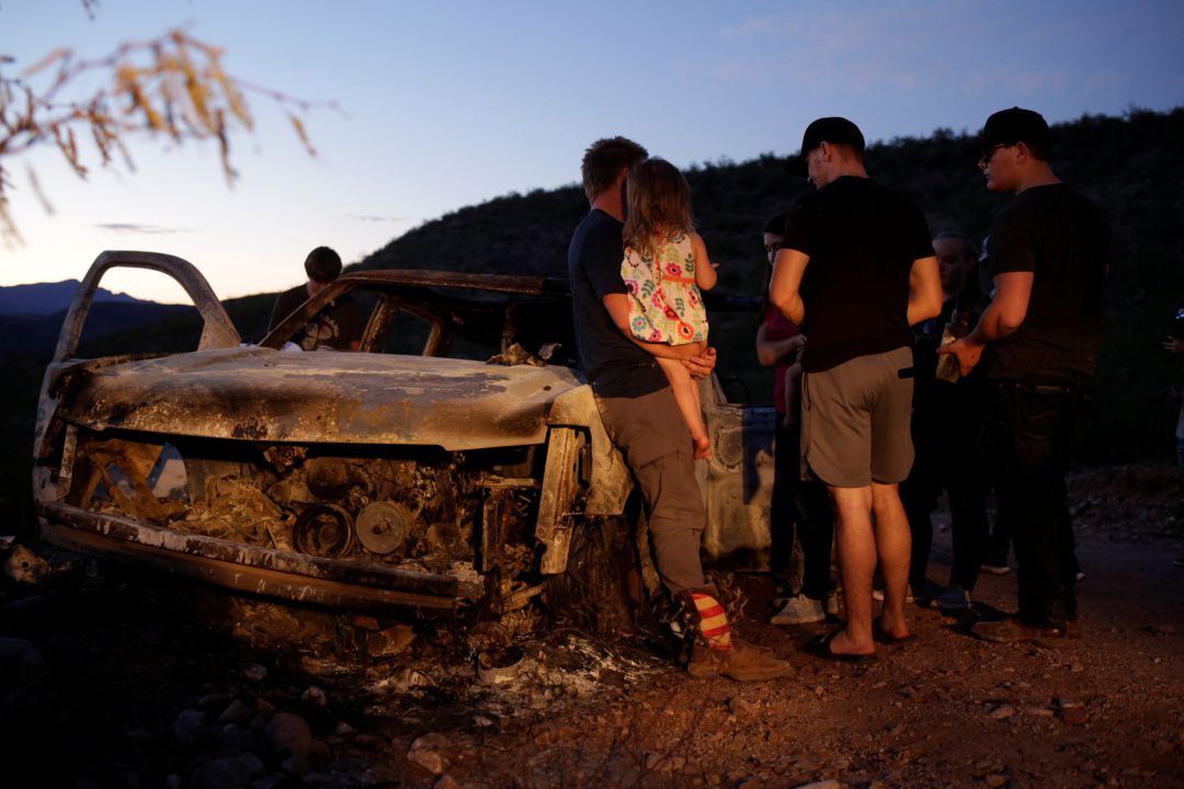 Miembros de la comunidad mormona observan el coche calcinado de la familia LeBarón. Miembros de la comunidad mormona observan el coche calcinado de la familia LeBarón.