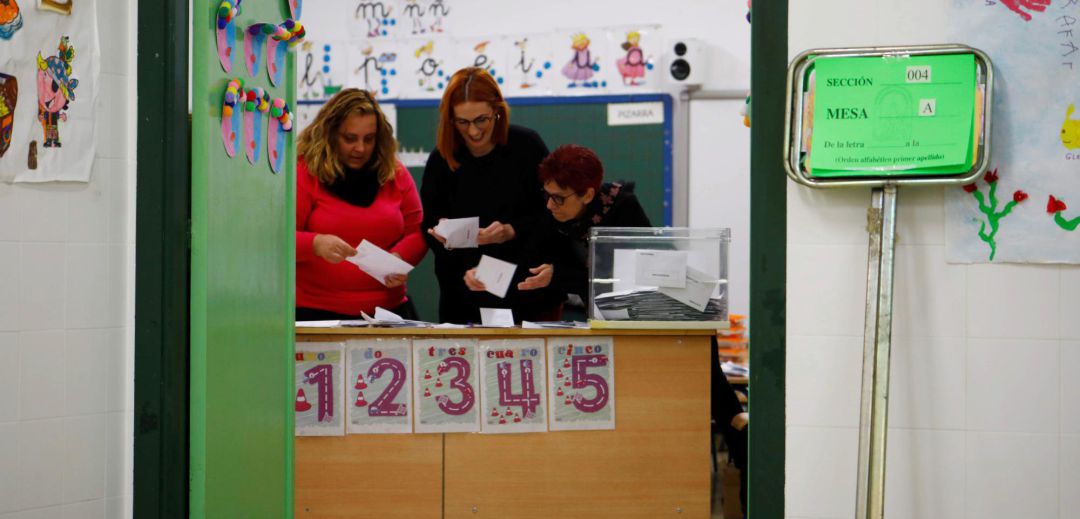Tres personas recuentan los votos en unas elecciones. Tres personas recuentan los votos en unas elecciones.