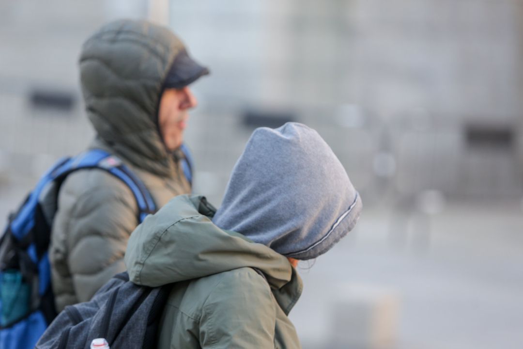 Dos jovenes se protegen del frío con abrigos y gorros mientras pasean durante un día de viento por Madrid (España). Dos jovenes se protegen del frío con abrigos y gorros mientras pasean durante un día de viento por Madrid (España).
