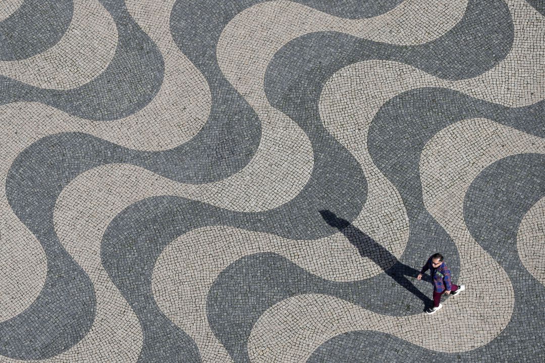 Un hombre pasea por una plaza de Lisboa Un hombre pasea por una plaza de Lisboa