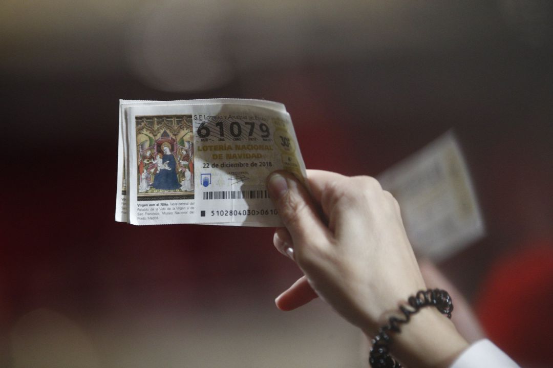 Una mujer agarra sus décimos antes de que comience el Sorteo Extraordinario de la Lotería de Navidad en el Teatro Real de Madrid Una mujer agarra sus décimos antes de que comience el Sorteo Extraordinario de la Lotería de Navidad en el Teatro Real de Madrid