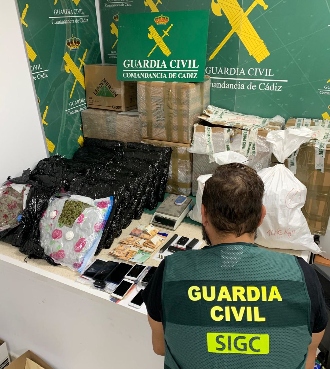 Un Guardia Civil, frente a la mercancía y los objetos incautados a la organización criminal Un Guardia Civil, frente a la mercancía y los objetos incautados a la organización criminal