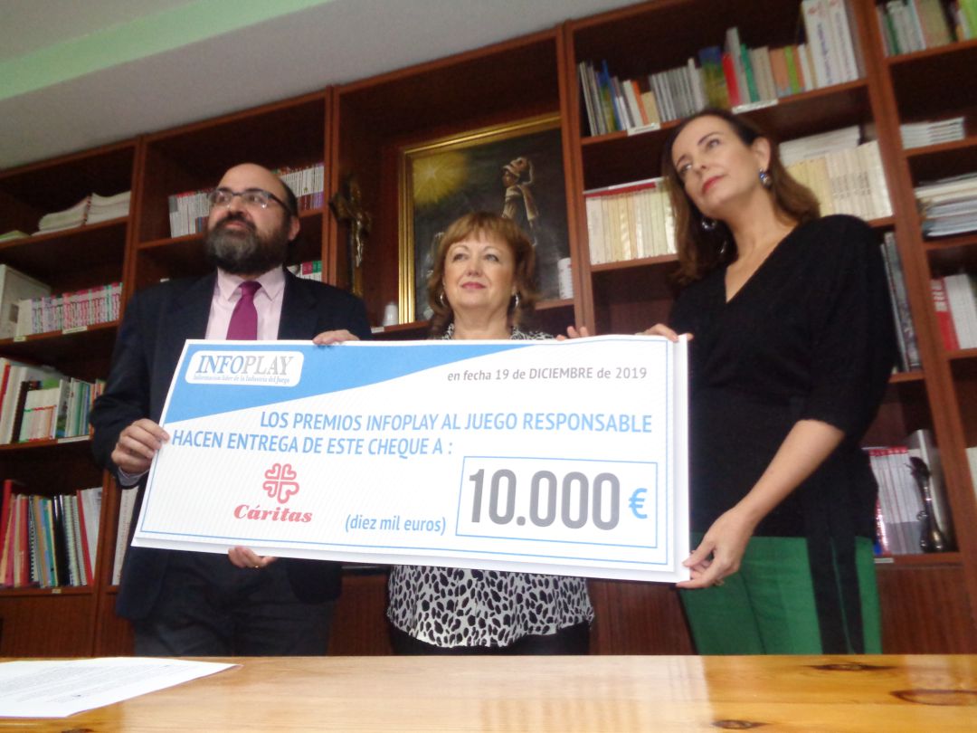 La presidenta de Cáritas recibe este cheque de la directora de Infojuego, acompañada de Máximo López La presidenta de Cáritas recibe este cheque de la directora de Infojuego, acompañada de Máximo López