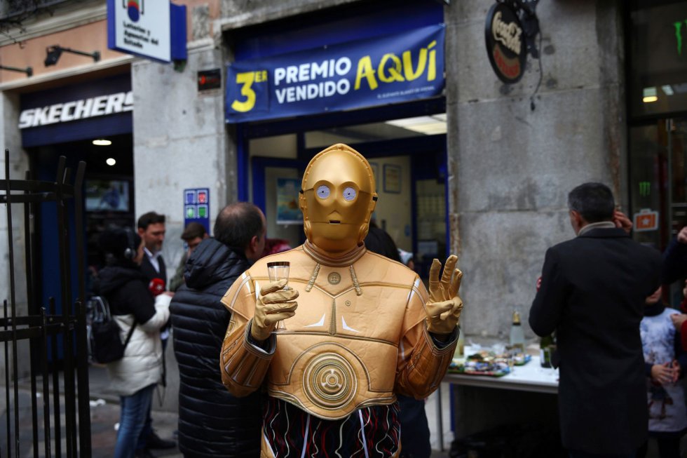 Una persona disfrazada del robot de la Guerra de las Galaxias C-3PO celebra en la administración de lotería 150 en la calle Arenal de Madrid donde se ha vendido una serie del tercer premio Una persona disfrazada del robot de la Guerra de las Galaxias C-3PO celebra en la administración de lotería 150 en la calle Arenal de Madrid donde se ha vendido una serie del tercer premio