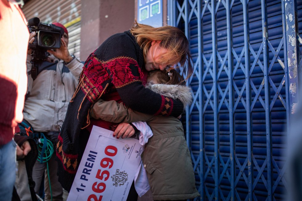Una mujer abraza a su hija mientras sujeta el número que ha sido premiado con el Primer Premio de la Lotería de Navidad, el Gordo de la Lotería, el 26.590, en Barcelona Una mujer abraza a su hija mientras sujeta el número que ha sido premiado con el Primer Premio de la Lotería de Navidad, el Gordo de la Lotería, el 26.590, en Barcelona