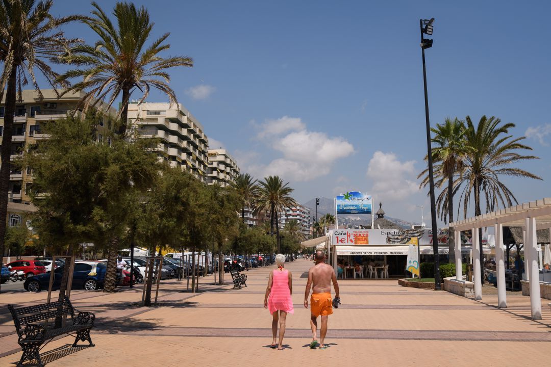 Una pareja caminando por el paseo marítimo de Fuengirola (Costa del Sol) Una pareja caminando por el paseo marítimo de Fuengirola (Costa del Sol)