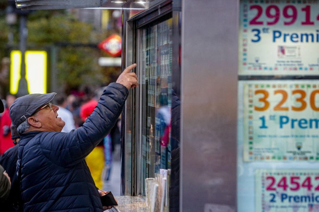 Un hombre señala el décimo de Lotería que quiere comprar en una Administración. Un hombre señala el décimo de Lotería que quiere comprar en una Administración.