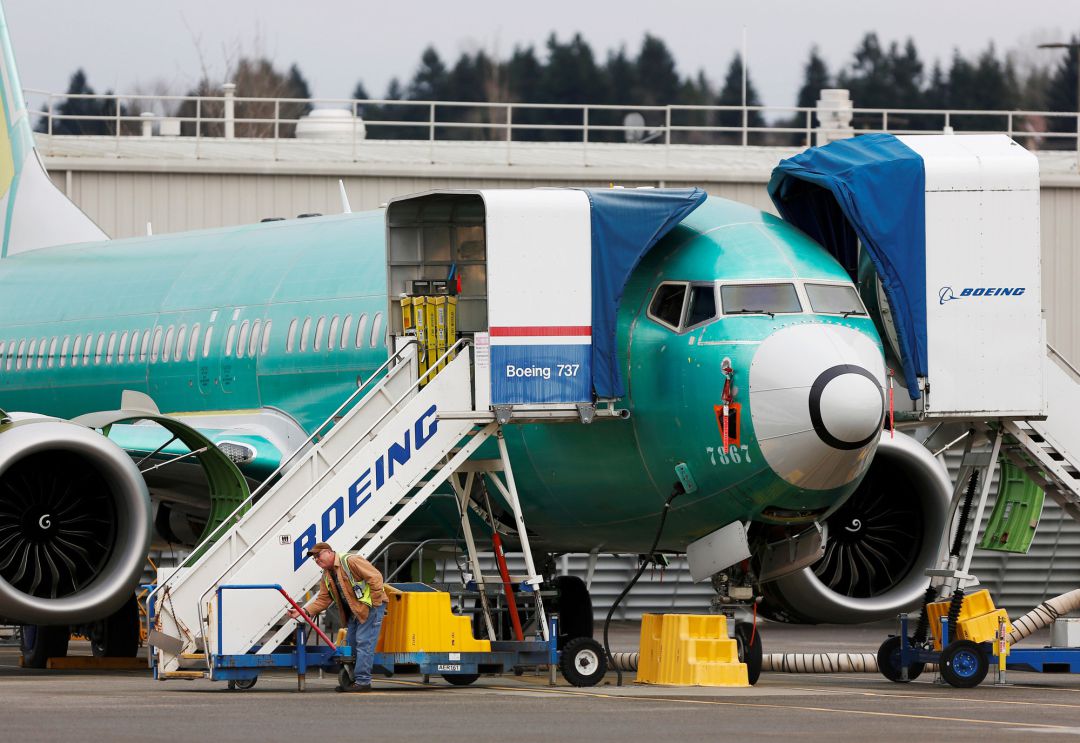 Un empleado trabaja cerca de Boeing 737. Un empleado trabaja cerca de Boeing 737.