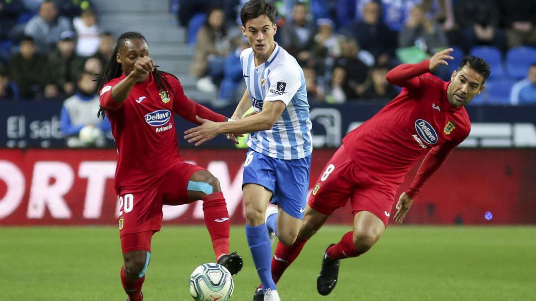 El malagueño Juanpi intenta salir airoso del acoso de Emmanuel y Márquez, del C.F. Fuenlabrada, durante el partido de la primera vuelta en La Rosaleda. El malagueño Juanpi intenta salir airoso del acoso de Emmanuel y Márquez, del C.F. Fuenlabrada, durante el partido de la primera vuelta en La Rosaleda.