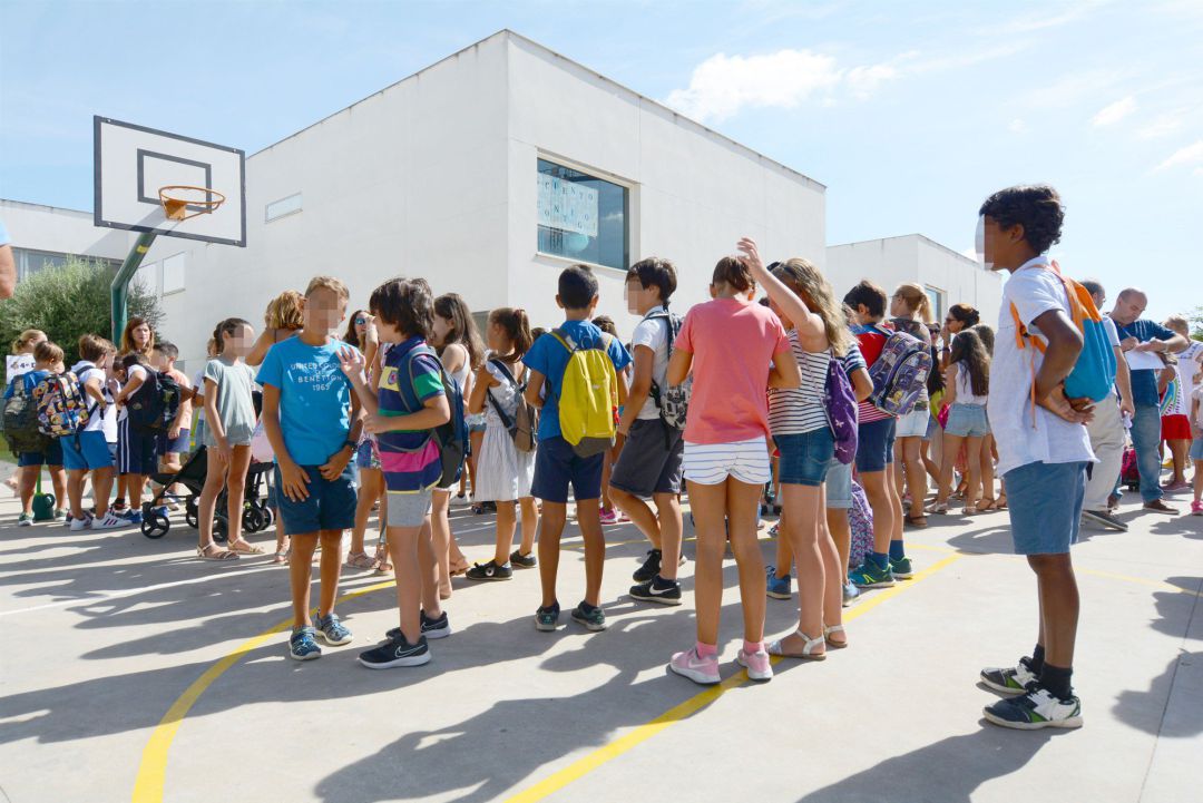 Alumnos de infantil y primaria esperan en el recreo del colegio Alumnos de infantil y primaria esperan en el recreo del colegio