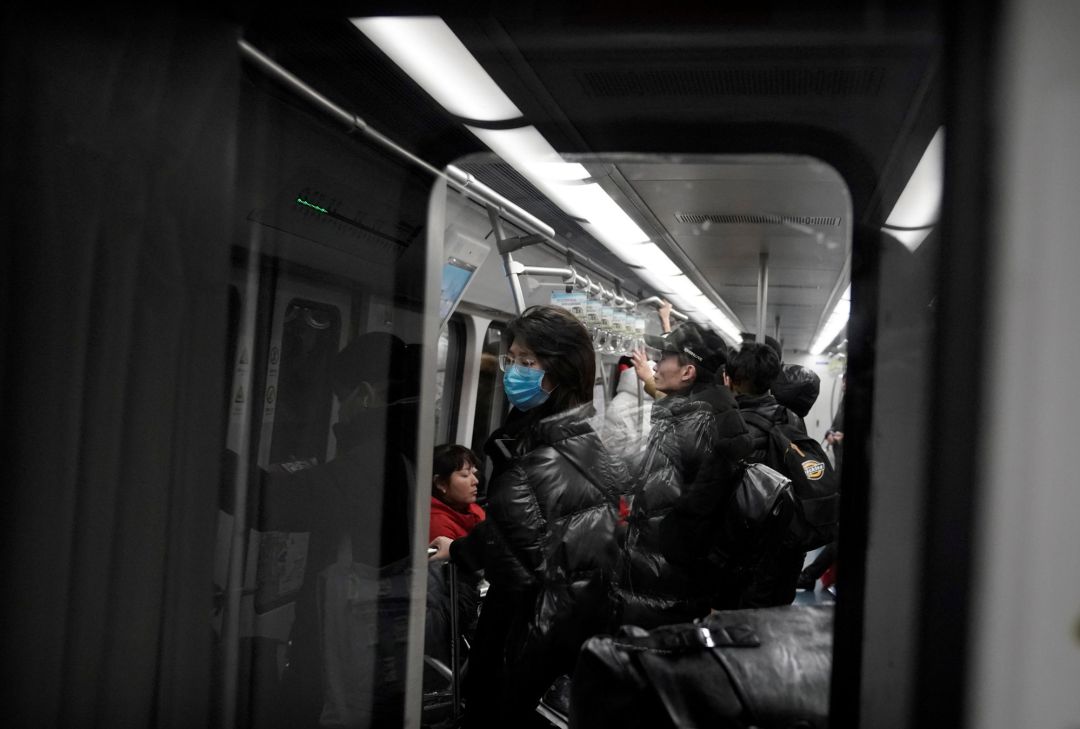 Una mujer con una máscara es retratada en el metro de Beijing Una mujer con una máscara es retratada en el metro de Beijing