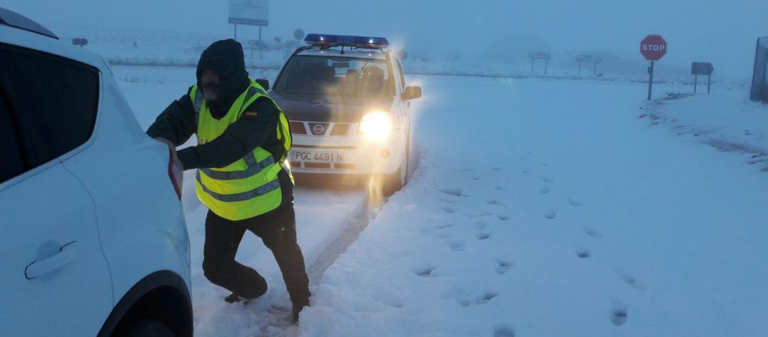 Un agente de la benemérita ayudando a un vehículo atrapado por la nieve Un agente de la benemérita ayudando a un vehículo atrapado por la nieve