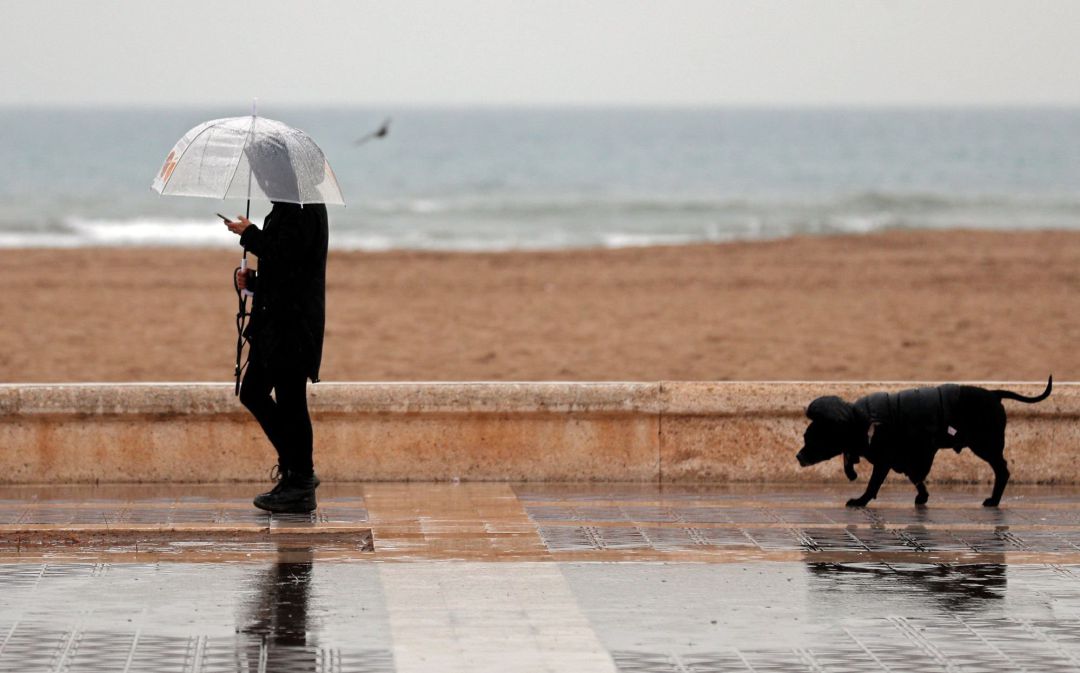 GRAFCVA1211. VALENCIA Una persona pasea bajo la lluvia cuando la borrasca Gloria, que trae este domingo un temporal de lluvia, nieve, viento y olas, ha puesto en alerta roja a la Comunidad Valenciana y a las Islas Baleares, mientras los avisos naranja se reparten por una veintena de provincias, según la Agencia Estatal de Meteorología (Aemet). GRAFCVA1211. VALENCIA Una persona pasea bajo la lluvia cuando la borrasca Gloria, que trae este domingo un temporal de lluvia, nieve, viento y olas, ha puesto en alerta roja a la Comunidad Valenciana y a las Islas Baleares, mientras los avisos naranja se reparten por una veintena de provincias, según la Agencia Estatal de Meteorología (Aemet).