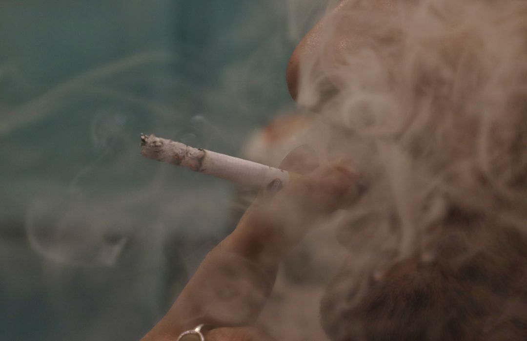 Foto de archivo de una persona fumando. Foto de archivo de una persona fumando.
