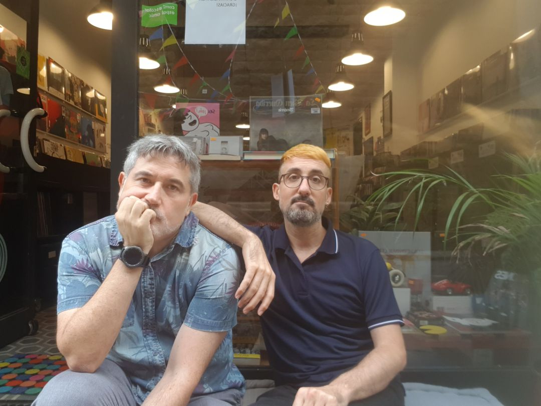 De izquierda a derecha: Joan y Rafa, sentados en el escaparate de la tienda del sello De izquierda a derecha: Joan y Rafa, sentados en el escaparate de la tienda del sello