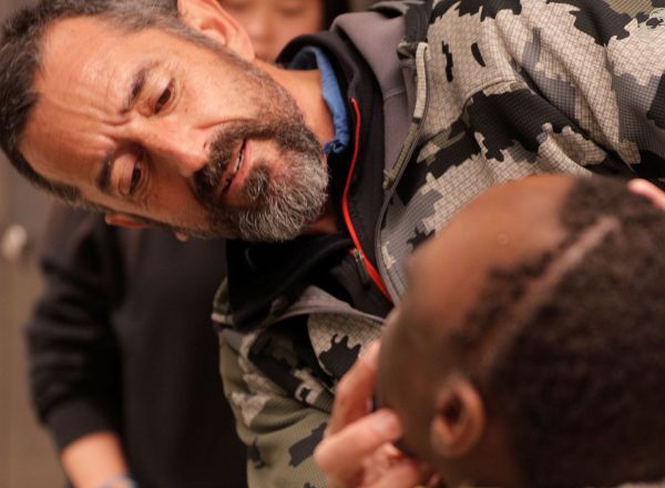 GRAFCVA1477. VALÉNCIA, 27/01/2020.- El cirujano Pedro Cavadas observa la cara de Emmanuelle, el niño congoleño de 10 años al que ha extirpado un tumor cráneo facial no maligno que formaba una masa mas grande que su cabeza y que, de no ser intervenido, le habría provocado la muerte "en muy malas condiciones y relativamente pronto". EFE/Kai Försterling