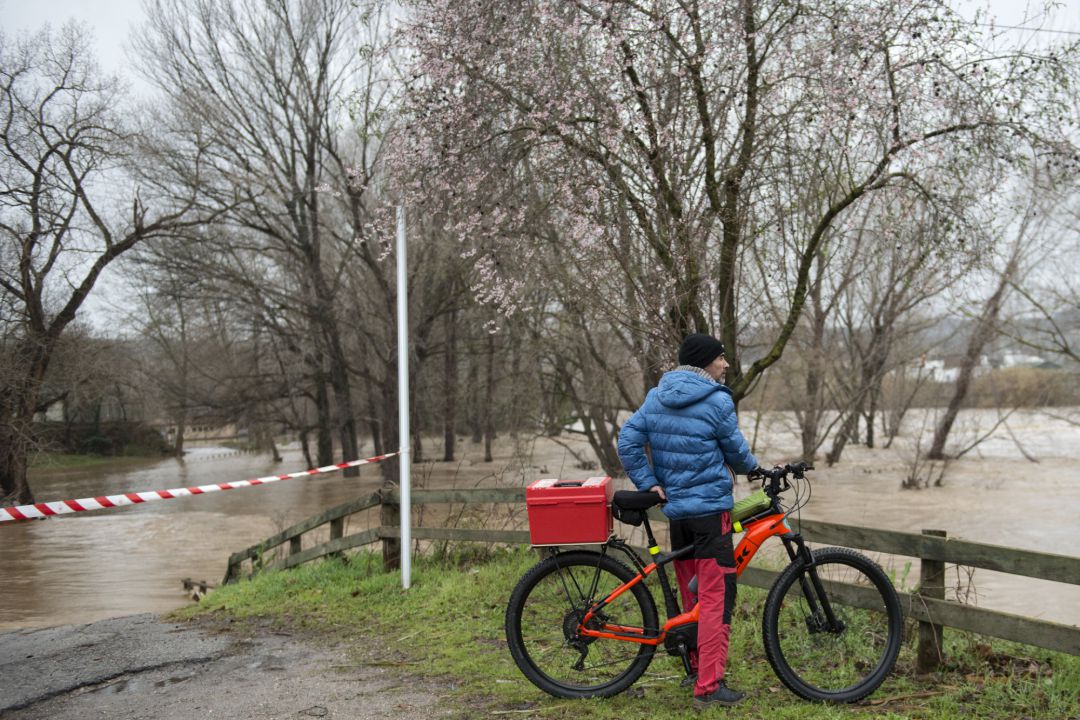 Un ciclista davant un Ter desbordat Un ciclista davant un Ter desbordat