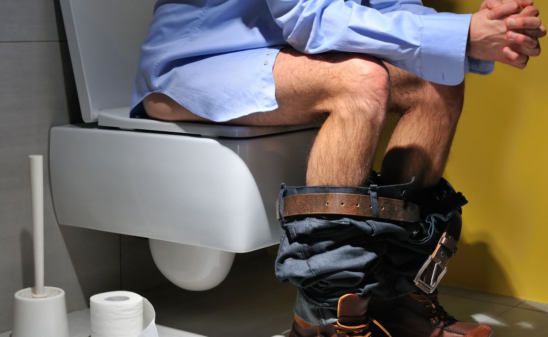 Un hombre sentado en el baño. Un hombre sentado en el baño.