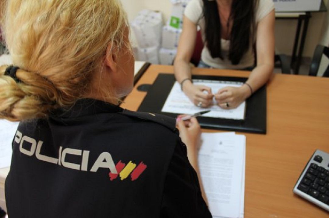 Agente de la Policía Nacional atiende a una mujer Agente de la Policía Nacional atiende a una mujer