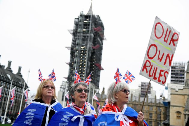 Tres mujeres afines al 'brexit' portan banderas y una pancarta con el lema "Nuestras propias reglas" en las inmediaciones de la Plaza del Parlamento en Londres. Tres mujeres afines al 'brexit' portan banderas y una pancarta con el lema "Nuestras propias reglas" en las inmediaciones de la Plaza del Parlamento en Londres.