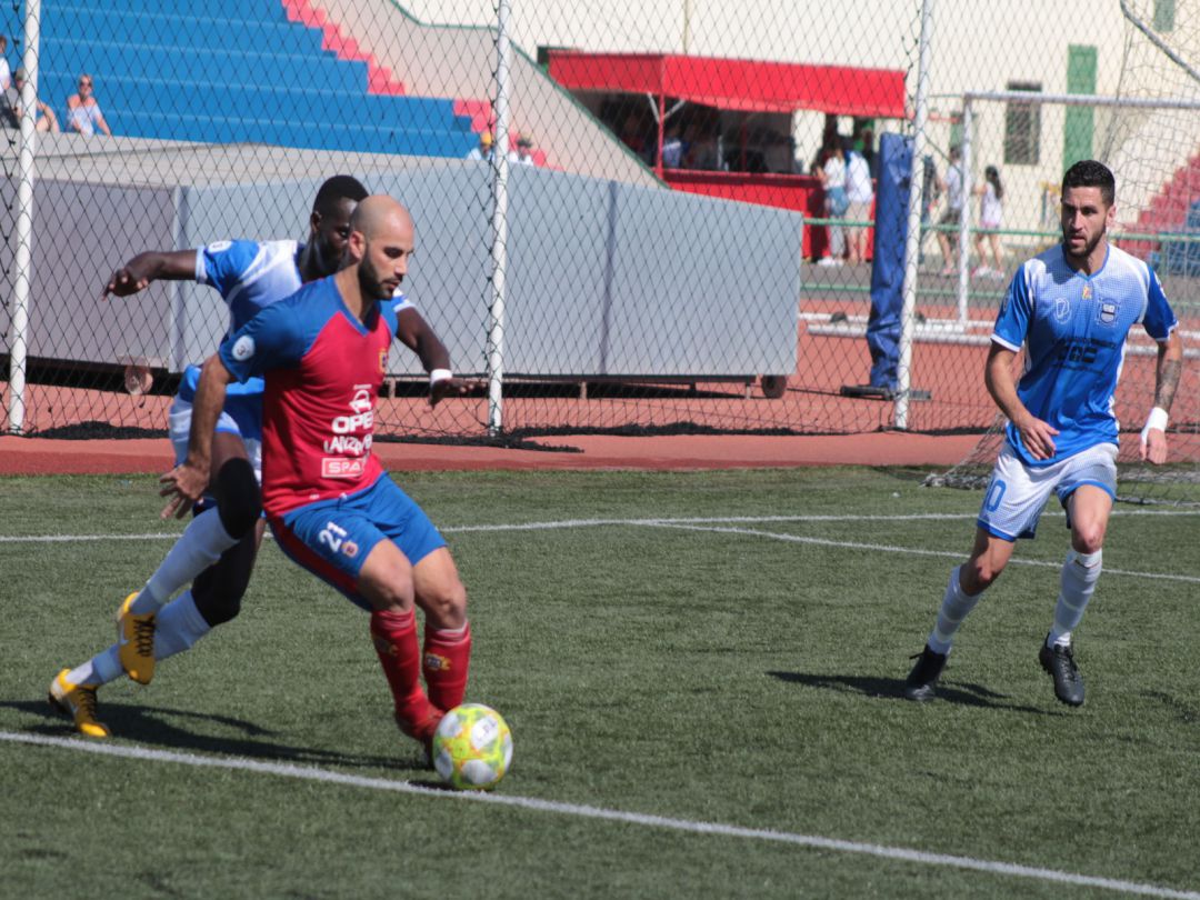 El rojillo Ayoze Pérez controlando un balón ante dos jugadores del Unión Puerto. El rojillo Ayoze Pérez controlando un balón ante dos jugadores del Unión Puerto.