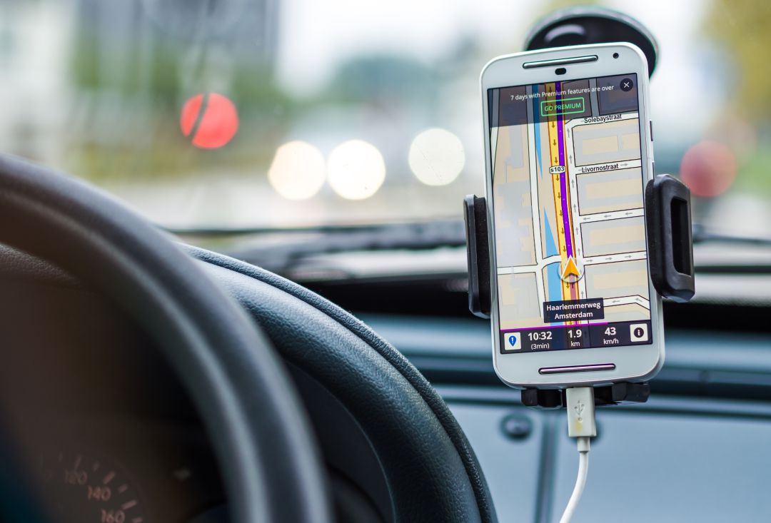 Un conductor fa servir una app de navegació al mòbil Un conductor fa servir una app de navegació al mòbil