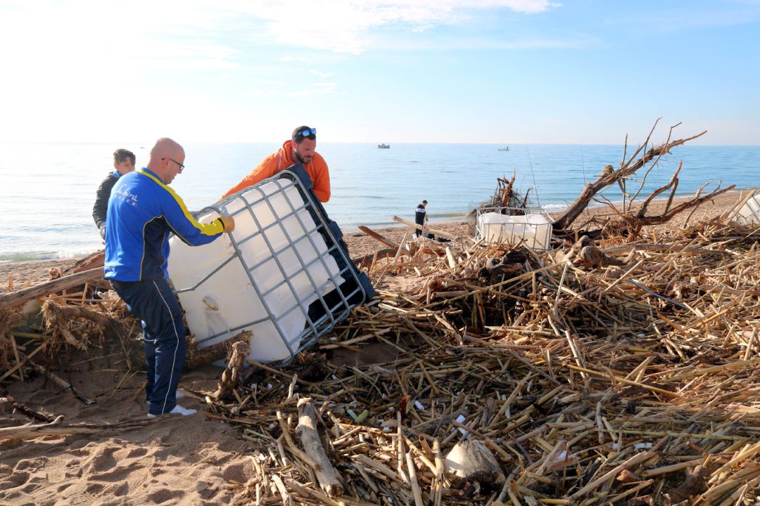 Imatge d'uns voluntaris retirant un gran contenidor de plàstic de la platja de Malgrat de Mar Imatge d'uns voluntaris retirant un gran contenidor de plàstic de la platja de Malgrat de Mar