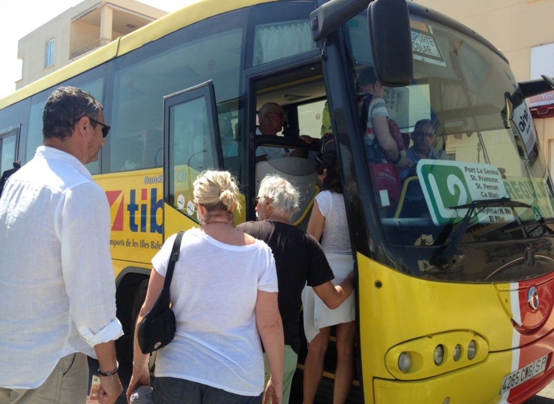 Viajeros subiendo a un autobús en Formentera Viajeros subiendo a un autobús en Formentera