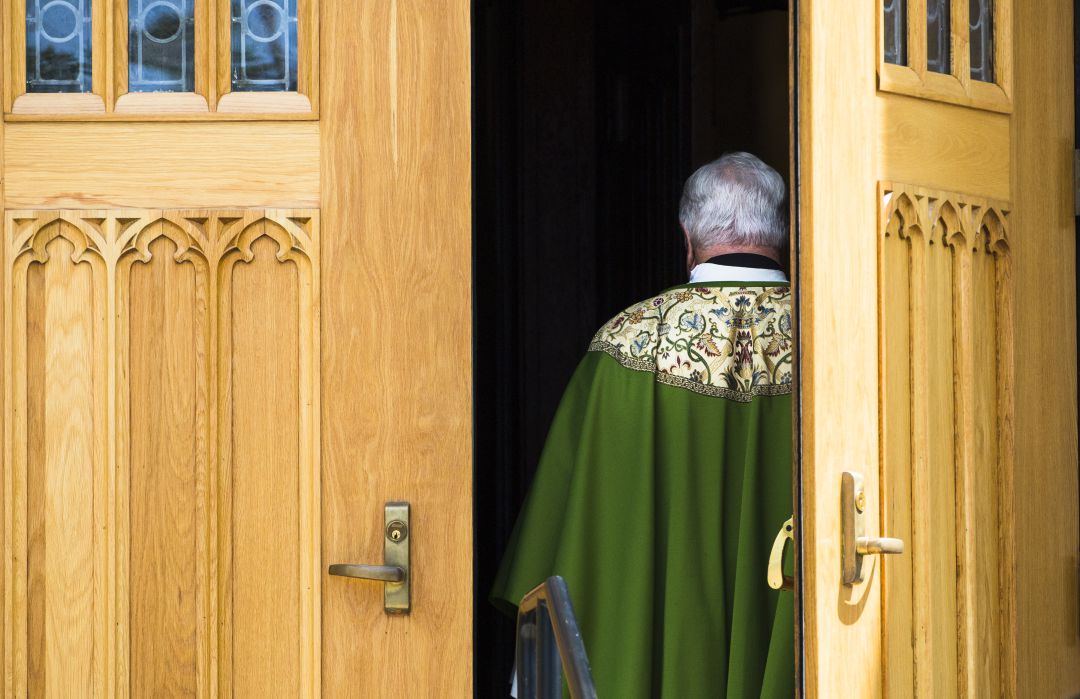 Un cura accede al interior de una iglesia. Un cura accede al interior de una iglesia.