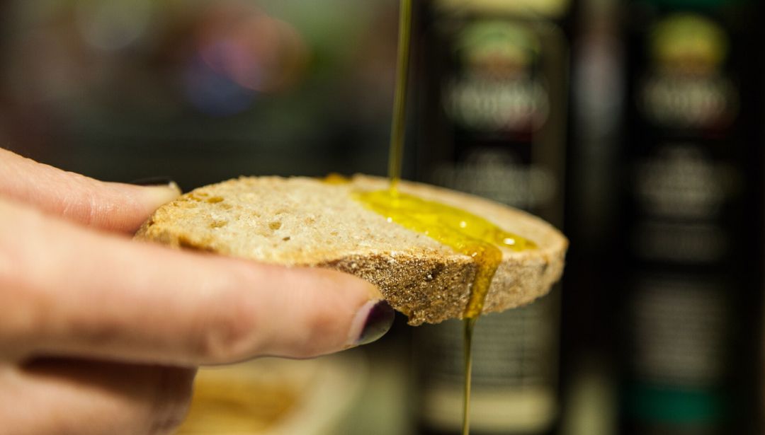 Aceite de oliva cayendo en un trozo de pan. Aceite de oliva cayendo en un trozo de pan.