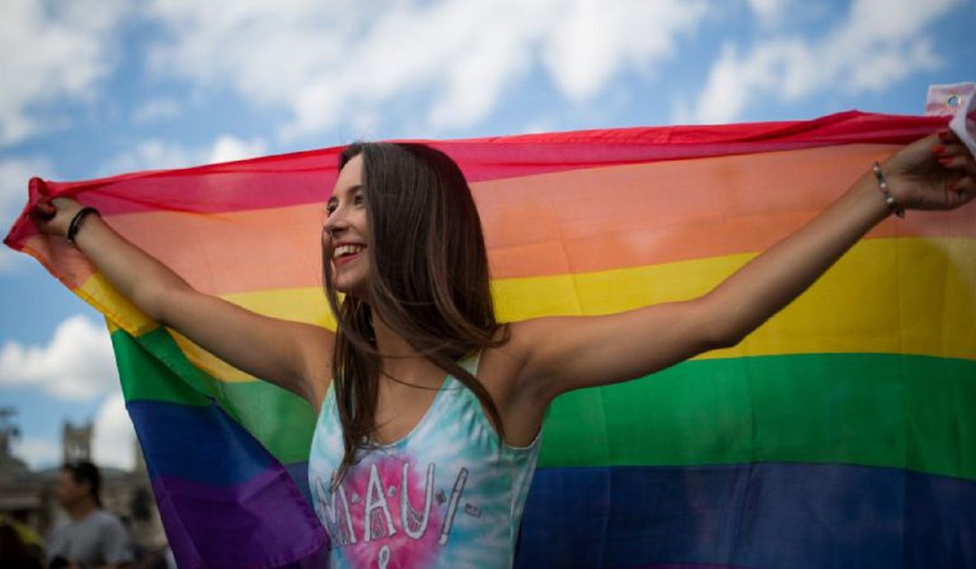 Una joven luce la bandera del Orgullo Gay. Una joven luce la bandera del Orgullo Gay.