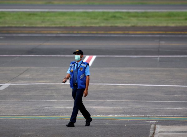 An aviation security officer wearing a protective mask walks at the tarmac of Halim Perdanakusuma airport, following the outbreak of the coronavirus in China, in Jakarta, Indonesia, February 15, 2020. REUTERS/Willy Kurniawan