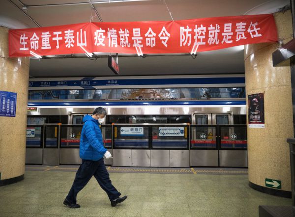 BEIJING, CHINA - FEBRUARY 15: A man walks past a banner saying "A Person's Life is Heavier Than Mount Tai, the Illness Orders Us to Do So, Prevention and Control is Our Responsibility" on February 15, 2020 in Beijing, China. (Photo by Andrea Verdelli/Getty Images)