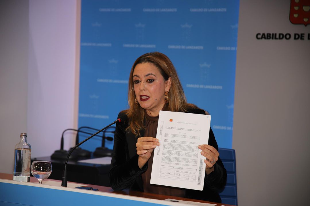 La presidenta del Cabildo de Lanzarote y del Consorcio del Agua, María Dolores Corujo, mostrando la petición de desestimiento de la subida de tarifas firmada por Echedey Eugenio. La presidenta del Cabildo de Lanzarote y del Consorcio del Agua, María Dolores Corujo, mostrando la petición de desestimiento de la subida de tarifas firmada por Echedey Eugenio.