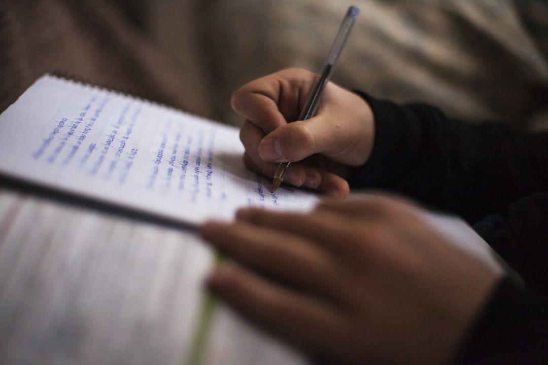 Un niño toma notas en un cuaderno en clase. Un niño toma notas en un cuaderno en clase.