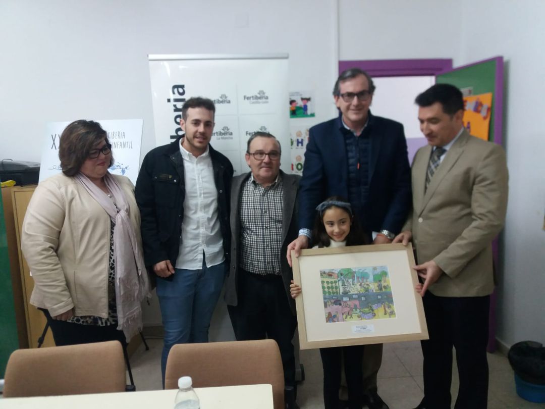Foto de familia, Zaira Sánchez Liébana, con una reproducción de su dibujo, acompañada de representantes del colegio, empresa, delegación y ayuntamiento Foto de familia, Zaira Sánchez Liébana, con una reproducción de su dibujo, acompañada de representantes del colegio, empresa, delegación y ayuntamiento