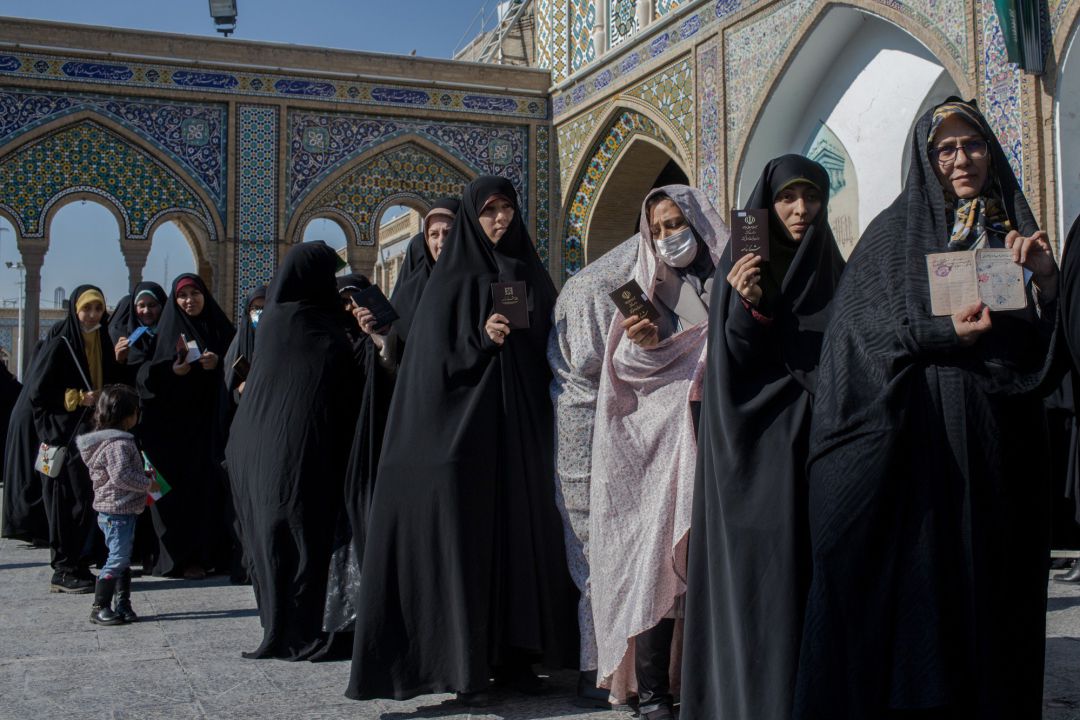Las mujeres hacen cola para emitir sus votos en Teheran. Algunas de ellas llevan máscaras después de la noticia del brote de coronavirus Las mujeres hacen cola para emitir sus votos en Teheran. Algunas de ellas llevan máscaras después de la noticia del brote de coronavirus