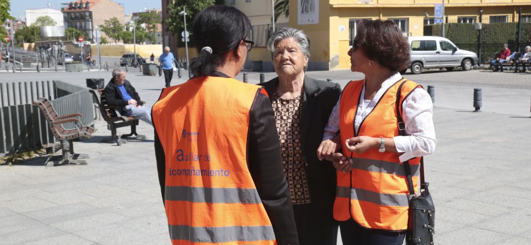 Dos de los auxiliares de acompañamiento junto a una persona mayor Dos de los auxiliares de acompañamiento junto a una persona mayor
