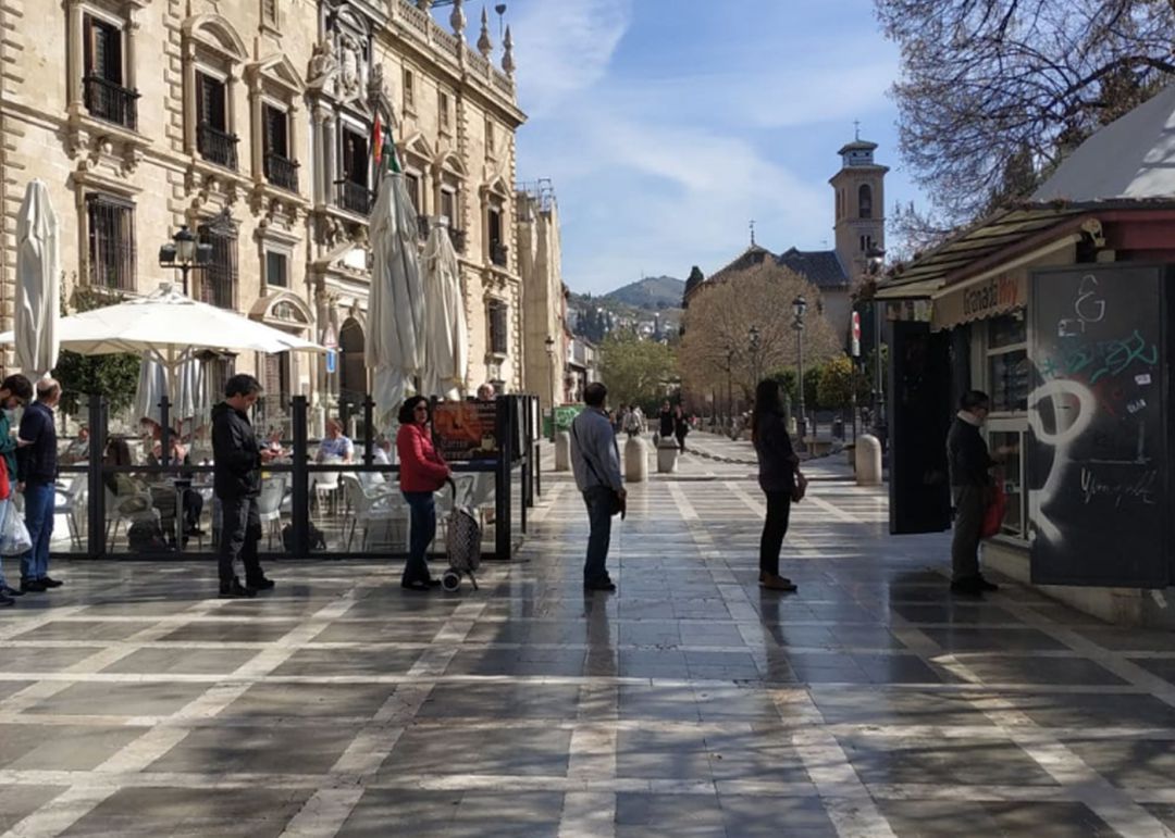 Las personas que la mañana del sábado 14 de marzo hacen cola para comprar en el kiosko de Plaza Nueva, en Granada, guardan la distancia de seguridad recomendada ante el avance del coronavirus Las personas que la mañana del sábado 14 de marzo hacen cola para comprar en el kiosko de Plaza Nueva, en Granada, guardan la distancia de seguridad recomendada ante el avance del coronavirus