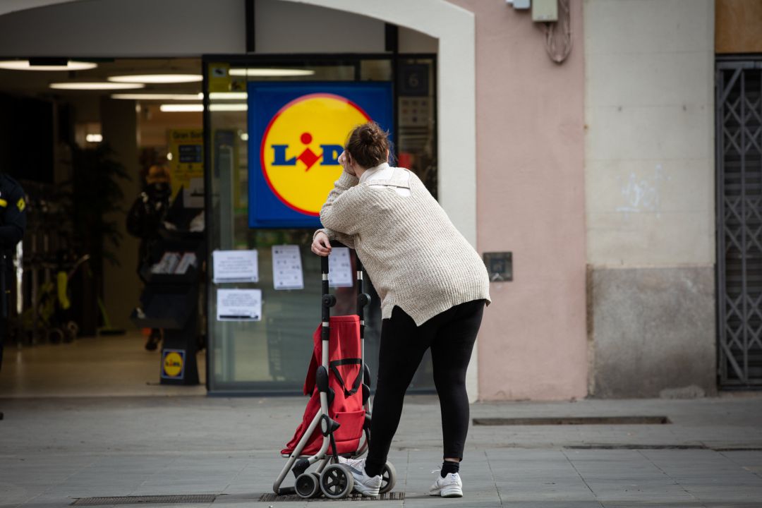 Una mujer espera con su carro de la compra a poder entrar a un supermercado Lidl, este martes. Una mujer espera con su carro de la compra a poder entrar a un supermercado Lidl, este martes.