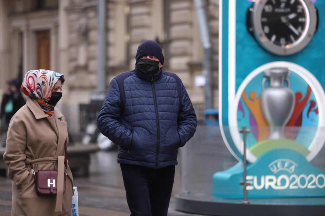 Dos personas pasan delante de un cartel de la Eurocopa 2020. Dos personas pasan delante de un cartel de la Eurocopa 2020.